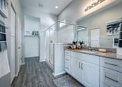 Thumbnail 7 of 15 - A bathroom with a walk-in shower and double vanity.