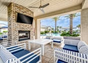 Thumbnail 11 of 15 - A patio with a fireplace and a television on the wall.