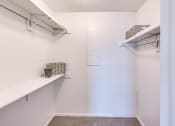 Thumbnail 14 of 24 - a walk in closet with shelves and two shelves on the wall