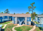 Thumbnail 18 of 24 - our apartments feature a spacious courtyard with trees and a blue building with stairs