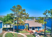 Thumbnail 20 of 24 - an aerial view of a house with trees and a blue fence