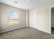 Thumbnail 5 of 40 - an empty bedroom with a door and a window at Diamond Ridge Townhomes, Oklahoma City, OK  