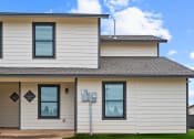 Thumbnail 10 of 40 - the front of a white house with a gray roof at Diamond Ridge Townhomes, Oklahoma   