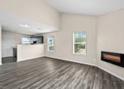 Thumbnail 4 of 40 - an empty living room with a fireplace and a kitchen at Diamond Ridge Townhomes, Oklahoma City  