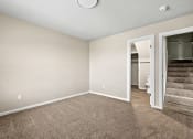 Thumbnail 6 of 40 - an empty living room with carpeting and a doorway to a bathroom at Diamond Ridge Townhomes, Oklahoma City, OK 73114  
