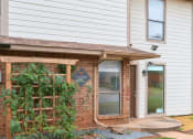 Thumbnail 29 of 40 - the front porch of a house with a brick wall and a door at Diamond Ridge Townhomes, Oklahoma City  