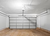 Thumbnail 28 of 40 - the inside of a garage with white walls and a concrete floor at Diamond Ridge Townhomes, Oklahoma   