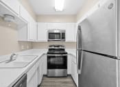 Thumbnail 21 of 40 - a white kitchen with stainless steel appliances and white cabinets at Diamond Ridge Townhomes, Oklahoma ,73114