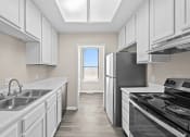 Thumbnail 11 of 40 - a kitchen with white cabinets and stainless steel appliances and a window at Diamond Ridge Townhomes, Oklahoma City Oklahoma   