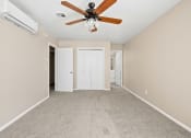 Thumbnail 24 of 40 - an empty living room with a ceiling fan and carpet at Diamond Ridge Townhomes, Oklahoma City, OK  