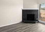 Thumbnail 14 of 40 - an empty living room with a fireplace and a window at Diamond Ridge Townhomes, Oklahoma City, OK 73114  