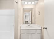 Thumbnail 19 of 40 - a bathroom with a sink and a mirror and a shower at Diamond Ridge Townhomes, Oklahoma City  