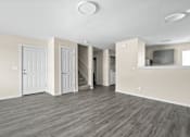 Thumbnail 31 of 40 - an empty living room with white walls and wood flooring at Diamond Ridge Townhomes, Oklahoma   
