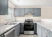 Thumbnail 30 of 40 - a kitchen with gray cabinets and white counter tops and a stove and sink at Diamond Ridge Townhomes, Oklahoma City Oklahoma   