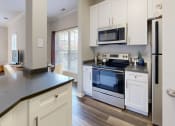 Thumbnail 4 of 35 - a kitchen with white cabinets and a stove and a microwave