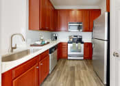 Thumbnail 14 of 35 - a kitchen with wooden cabinets and stainless steel appliances