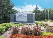 Thumbnail 35 of 35 - a sign at dwell at naperville entrance with flowers and trees