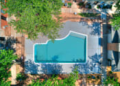 Thumbnail 24 of 29 - an aerial view of a swimming pool in the middle of some trees