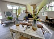Thumbnail 23 of 40 - a living room with a large wooden table with vases on top of it at Silver Reef Apartments, Colorado, 80228