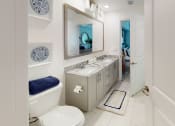 Thumbnail 15 of 35 - a bathroom with a toilet sink and mirror at The Lotus at Village Walk, Fort Myers, 33966
