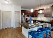 Thumbnail 2 of 24 - a kitchen with a granite counter top and stainless steel appliances at Integra 360 Apartments, Winter Springs, 32708