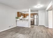 Thumbnail 4 of 14 - an empty living room and kitchen with a refrigerator