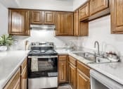 Thumbnail 1 of 14 - a kitchen with wooden cabinets and a stove and a sink