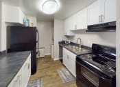 Thumbnail 1 of 27 - a kitchen with white cabinets and black appliances
