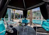 Thumbnail 31 of 36 - patio furniture around a swimming pool at the estates apartments at The Addison on Long Bayou Apartments, Seminole