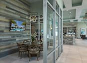Thumbnail 23 of 36 - a dining room with glass doors and a table and chairs at The Addison on Long Bayou Apartments, Seminole, FL