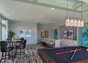 Thumbnail 16 of 36 - a game room with a pool table and a bar at The Addison on Long Bayou Apartments, Seminole, 33772