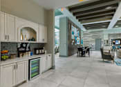 Thumbnail 18 of 36 - a kitchen with white cabinets and a table with chairs at The Addison on Long Bayou Apartments, Florida