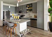 Thumbnail 2 of 36 - a kitchen with stainless steel appliances and gray cabinets at The Addison on Long Bayou Apartments, Seminole, 33772