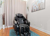 Thumbnail 30 of 40 - a massage chair sits in the corner of a room with a painting on the wall