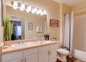 Thumbnail 9 of 26 - a bathroom with a toilet sink and shower at Magnolia Village Apartments, Florida