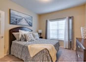 Thumbnail 7 of 26 - a bedroom with a bed and a dresser at Magnolia Village Apartments, Florida