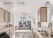 Thumbnail 26 of 26 - an open kitchen and living room with a couch in the background