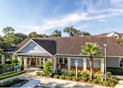 Thumbnail 26 of 26 - a building with a gray roof and palm trees in front of it at Magnolia Village Apartments, Jacksonville, Florida