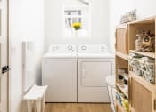 Thumbnail 9 of 33 - a small laundry room with a washing machine and a washer and dryer at Onyx at Westgate Apartments, Arizona