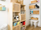 Thumbnail 17 of 33 - a room with a wooden shelf with baskets and other items on it at Onyx at Westgate Apartments, Glendale, 85305