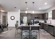 Thumbnail 7 of 51 - an open kitchen and dining room with a table and chairs at Enclave at 3230 Apartments, South Daytona