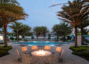 Thumbnail 25 of 51 - a large pool with a fire pit and chairs around it at Enclave at 3230 Apartments, Florida, 32119