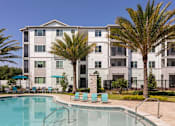 Thumbnail 18 of 51 - a building with palm trees next to a pool at Enclave at 3230 Apartments, Florida