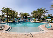Thumbnail 17 of 51 - a swimming pool with palm trees in a resort at Enclave at 3230 Apartments, South Daytona, FL, 32119