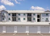 Thumbnail 47 of 51 - A large white building with multiple garage doors in front at Enclave at 3230 Apartments, South Daytona, 32119