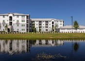 Thumbnail 48 of 51 - A large building with a pond in front of it at Enclave at 3230 Apartments, South Daytona, FL, 32119