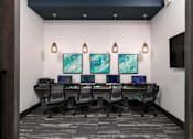 Thumbnail 39 of 51 - a conference room with a long desk with computers and chairs at Enclave at 3230 Apartments, South Daytona, 32119