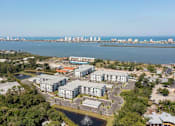 Thumbnail 50 of 51 - A large building complex is situated in a green area with a fountain in front of it at Enclave at 3230 Apartments, South Daytona, Florida