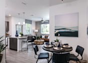 Thumbnail 9 of 51 - A dining room with a table set for four and a painting on the wall at Enclave at 3230 Apartments, Florida