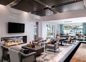 Thumbnail 31 of 51 - A modern living room with a fireplace and a television at Enclave at 3230 Apartments, South Daytona